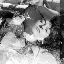 a black and white photo of a woman laying on a bed related to Sweet Dreams in Style: The KidKraft Princess Toddler Bed