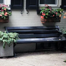 a black bench with two planters on top of it related to Cozy Up Your Entryway with Functional Benches and Baskets