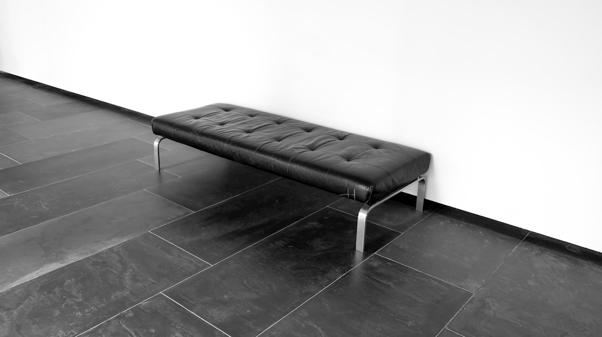 A black leather bench on a tiled floor. related to Stunning Modern Entryway Benches to Welcome Your Guests
