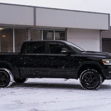 a black truck parked in front of a building related to Find Your Perfect Ride: Dodge Ram Truck Bed for Sale