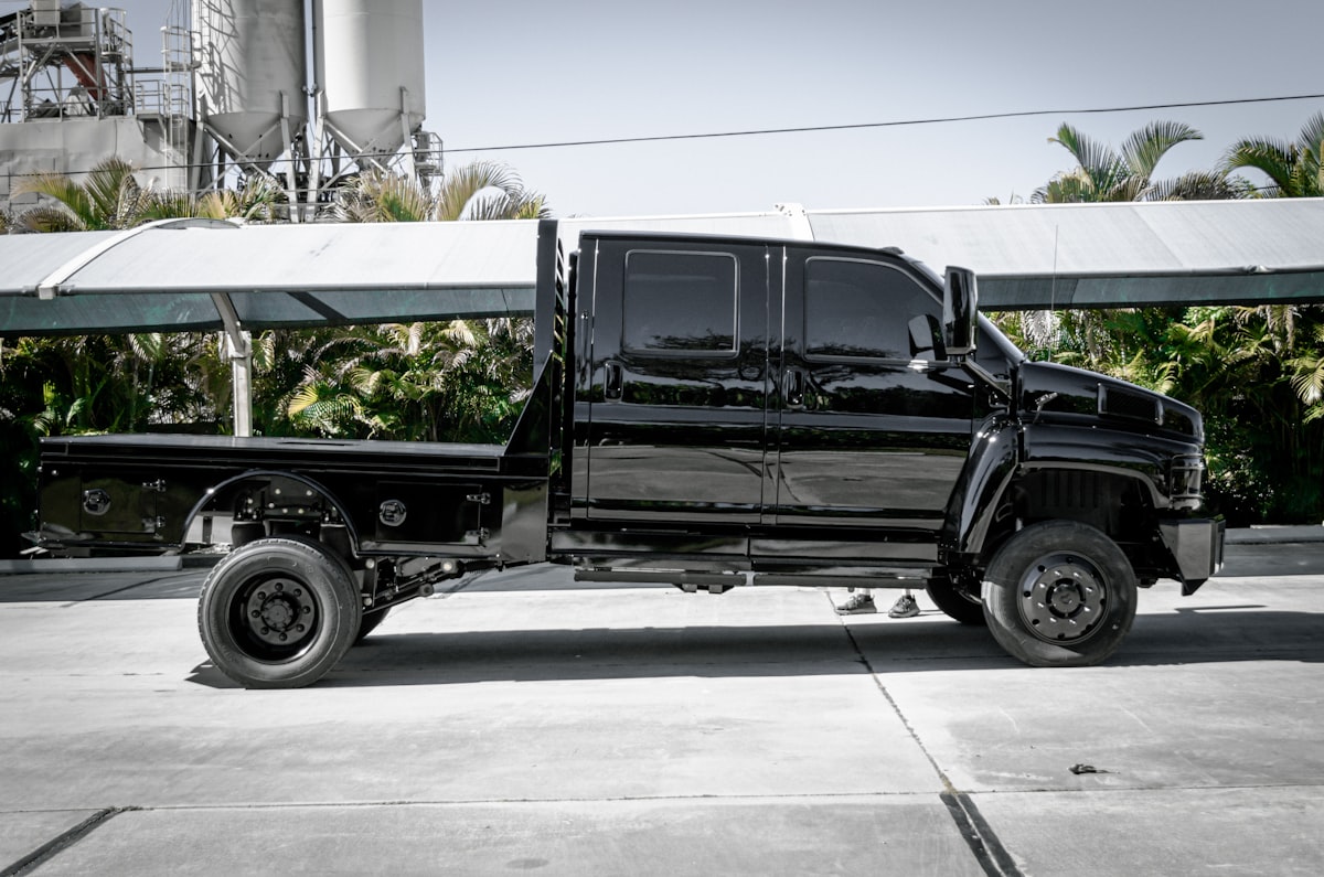 a black truck parked in front of a factory related to Find the Perfect Used Utility Bed for Your Needs