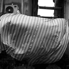 a blanket is draped over a window sill related to Transform Your Bedroom with a Striped Bed Skirt
