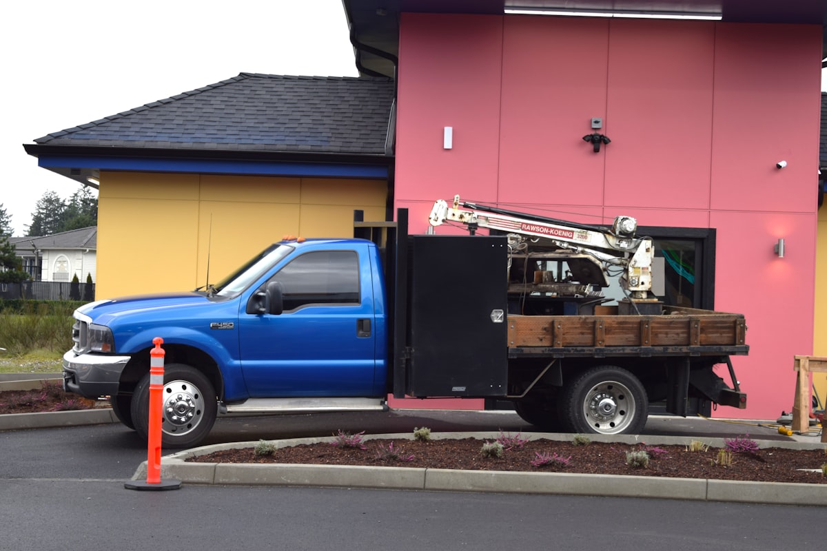 a blue truck parked in front of a pink building related to Ultimate Welding Truck Beds: A Comprehensive Guide