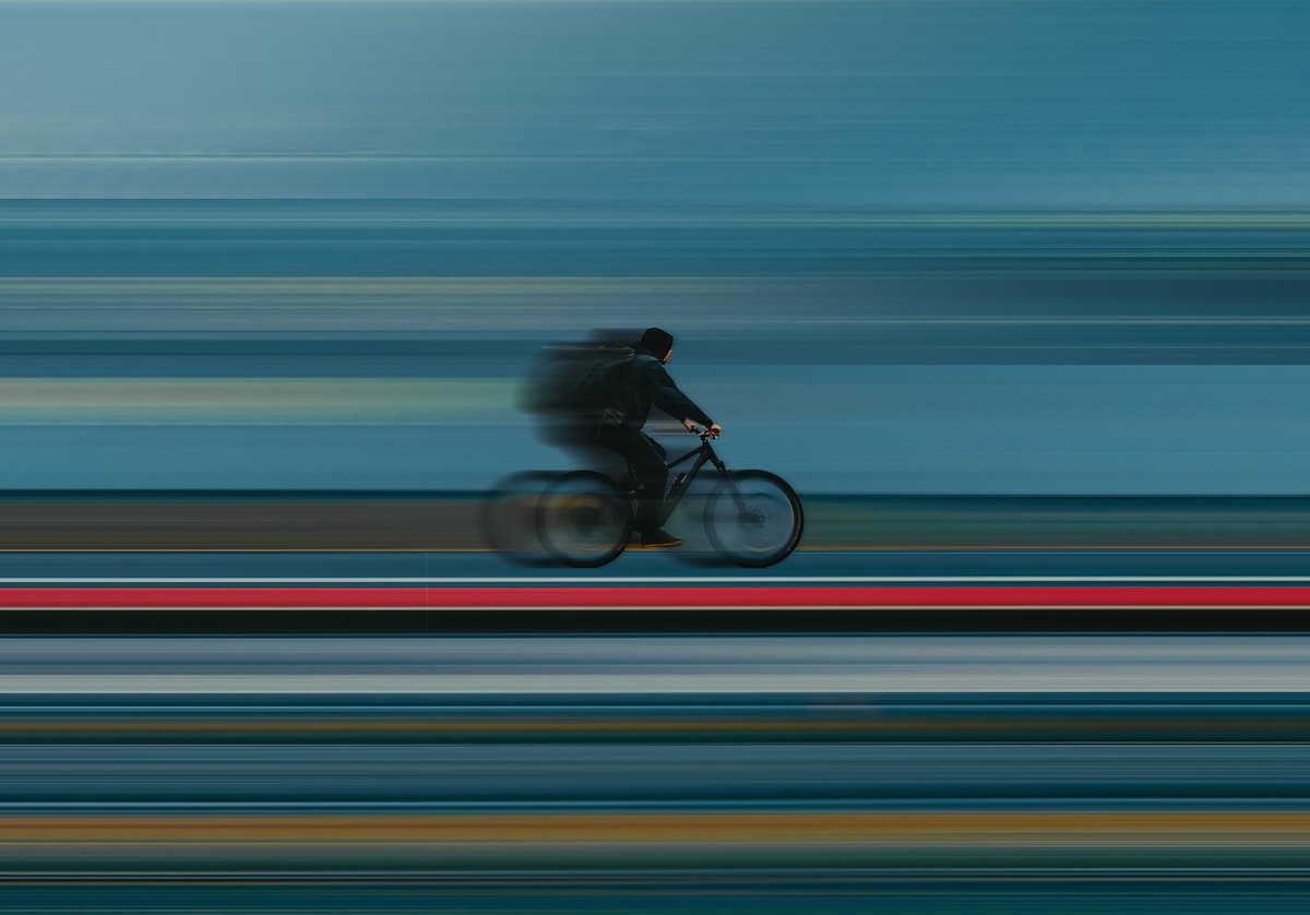 a blurry photo of a person riding a bike related to Speed into Childhood with a Blue Race Car Toddler Bed