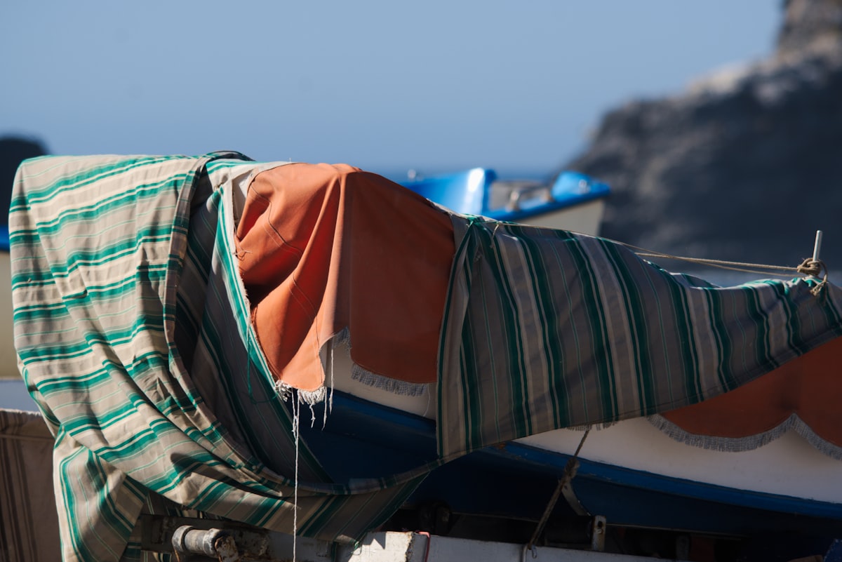 A boat covered in a blanket on a beach related to Stylish Bedding Sets for a Coastal Home
