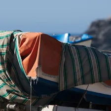 A boat covered in a blanket on a beach related to Stylish Bedding Sets for a Coastal Home