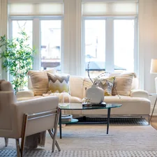 A bright, elegant living room with a sofa and armchair. related to Elevate Your Living Room Style with Tailored Valances
