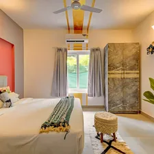 A bright, modern bedroom with a bed, wardrobe, and plant. related to Ultimate Guide to Air Beds for Comfort