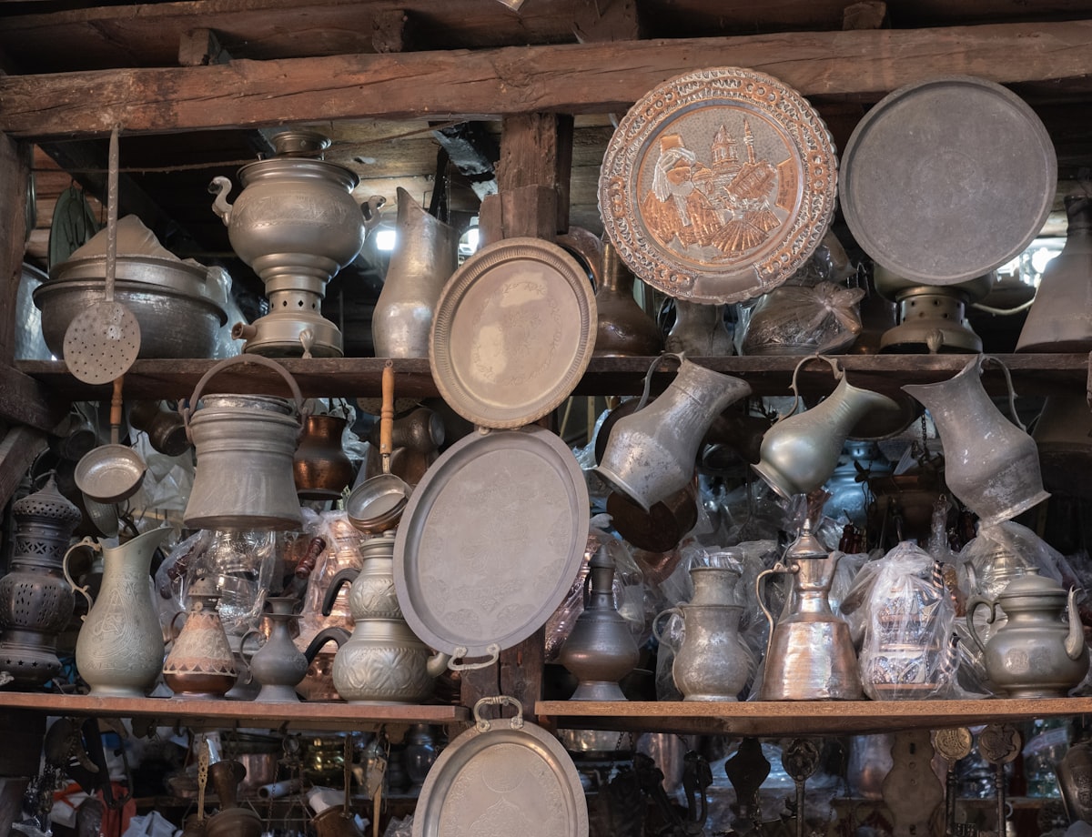 A bunch of pots and pans that are on a shelf related to Cast Iron Chiminea for Sale - One of a Kind Decorative Metal Art