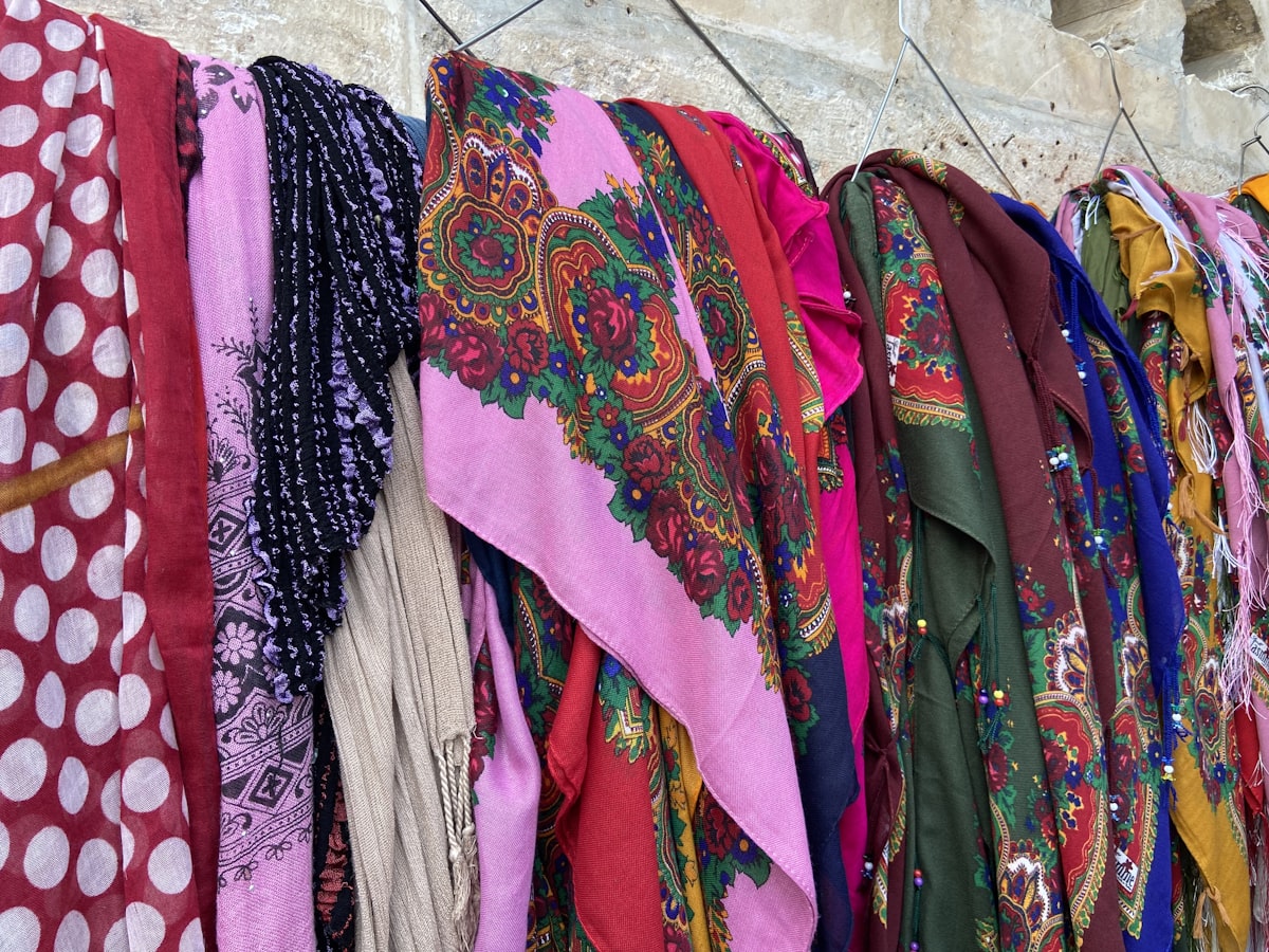 a bunch of scarves are hanging on a wall related to How to Hang Scarf Valances