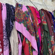 a bunch of scarves are hanging on a wall related to How to Hang Scarf Valances