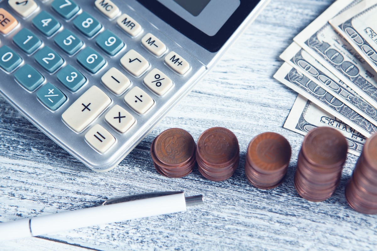 a calculator, pen, and money on a table related to Find Budget-Friendly Valances for Your Kitchen