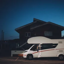 a camper van parked in front of a house at night related to Exploring the Best Motorhomes with Bunk Beds for Family Adventures