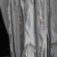 A cat sitting on a window sill in front of a curtain related to Statement Draperies: Embrace Elegance with Contemporary Curtain Valances