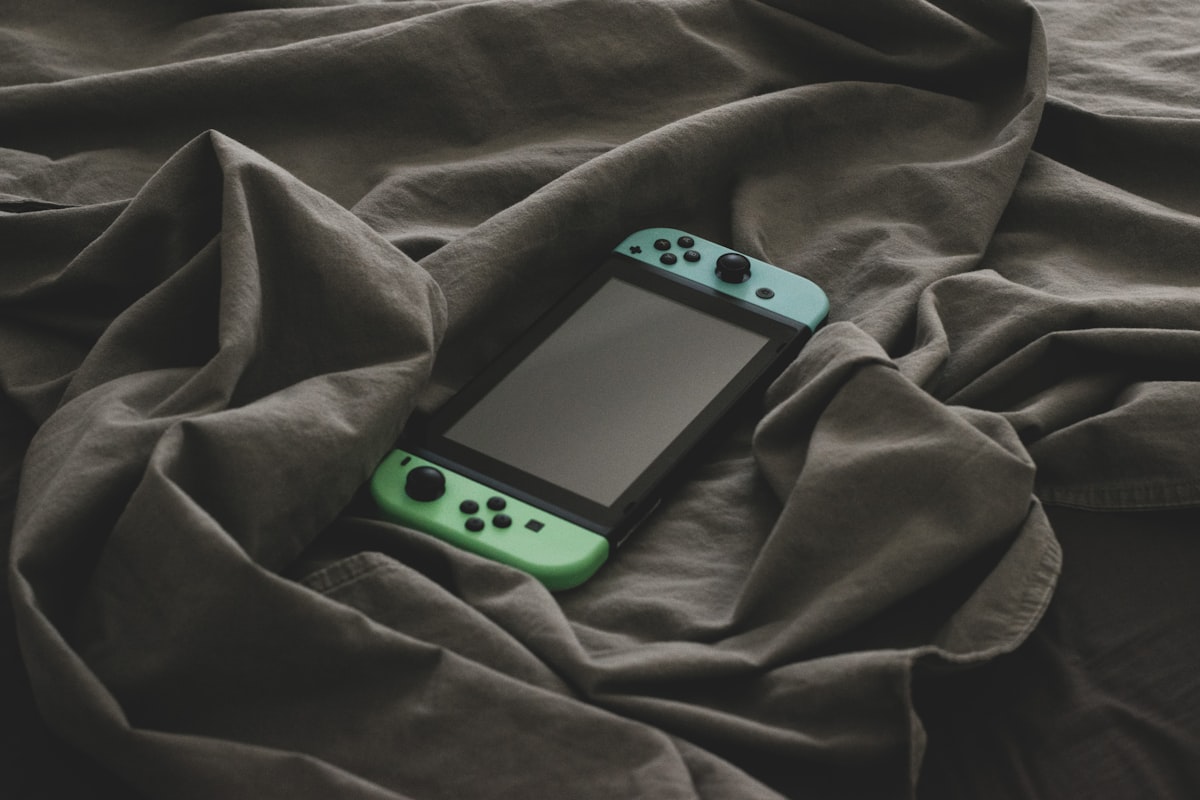 a cell phone on a blanket related to Transform Your Gaming Space: The Ultimate Guide to Gaming Bed Sheets