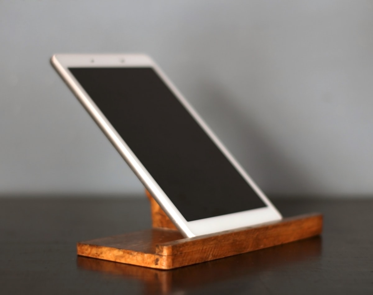 a cell phone sitting on top of a wooden stand related to The Ultimate Guide to Choosing the Perfect Tablet Bed Stand