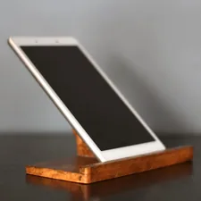 a cell phone sitting on top of a wooden stand related to The Ultimate Guide to Choosing the Perfect Tablet Bed Stand