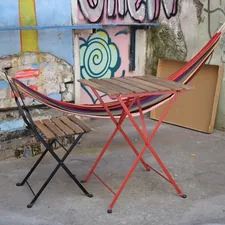 a chair and a table in front of a wall with graffiti related to Ultimate Comfort: The Indoor Hammock Bed with Stand