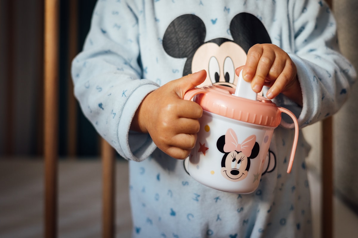 a child holding a cup related to Choosing the Perfect Minnie Toddler Bed Set for Your Little One