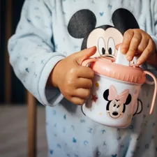 a child holding a cup related to Choosing the Perfect Minnie Toddler Bed Set for Your Little One
