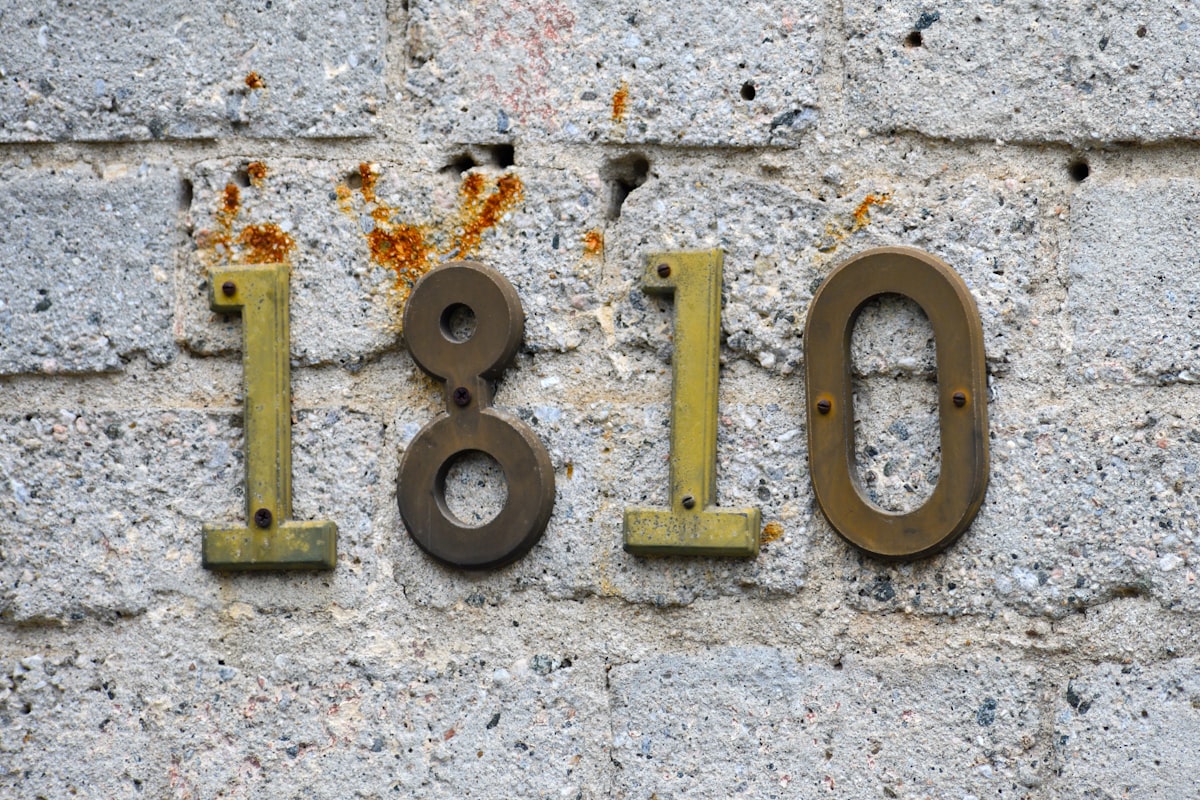 A classic street number sign on an old whitewashed brick building. related to Uncovering the Journey of 'Bed Number Ten': A Story of Resilience and Healing