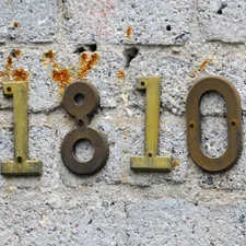 A classic street number sign on an old whitewashed brick building. related to Uncovering the Journey of 'Bed Number Ten': A Story of Resilience and Healing