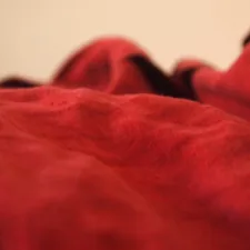 a close up of a red blanket on a bed related to The Ultimate Comfort: Bean Bag Beds with Blankets