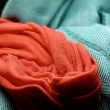 A close up of a red cloth on a chair related to Coral and Teal Bedding: A Refreshing Oasis for Your Bedroom