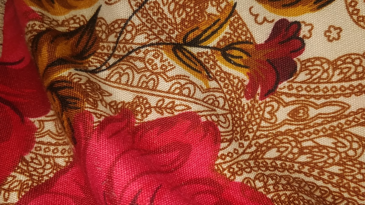 a close up of a red flower on a fabric related to Transform Your Bedroom with Exquisite Indian Print Bedding