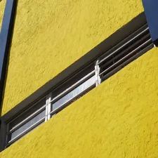 a close up of a window on a yellow building related to A Comprehensive Guide to Window Valance Clips