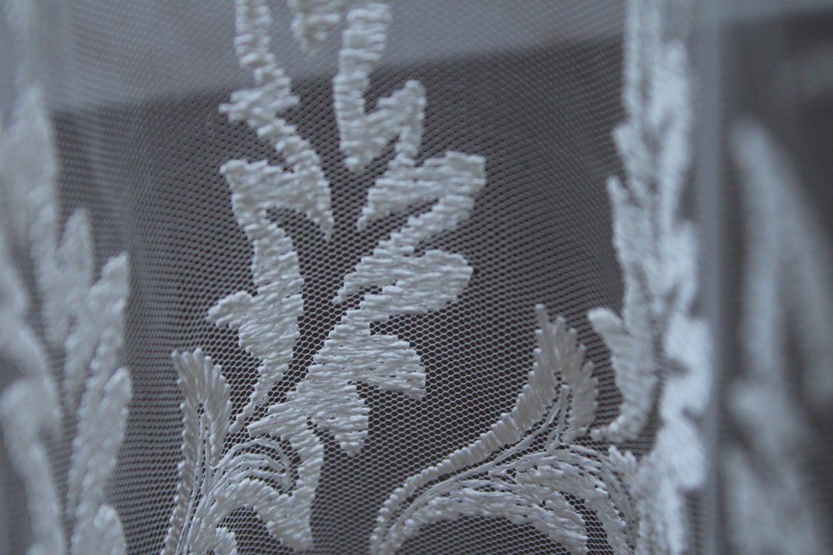 A close up of a window with white lace on it related to Elegant and Timeless: The Beauty of Damask Valance Curtains