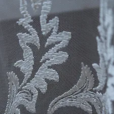 A close up of a window with white lace on it related to Elegant and Timeless: The Beauty of Damask Valance Curtains
