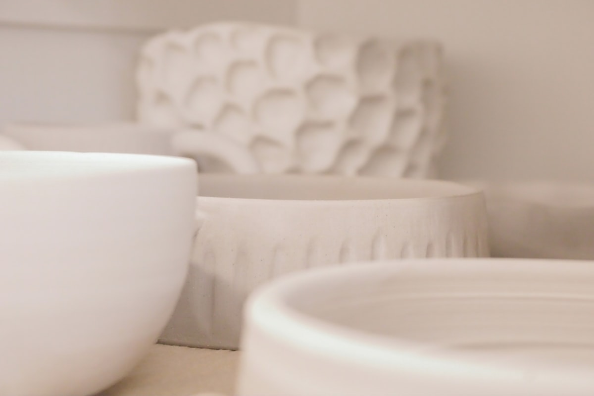 a close up of some white bowls on a table related to Essential Guide to Pots and Pans for Every Kitchen