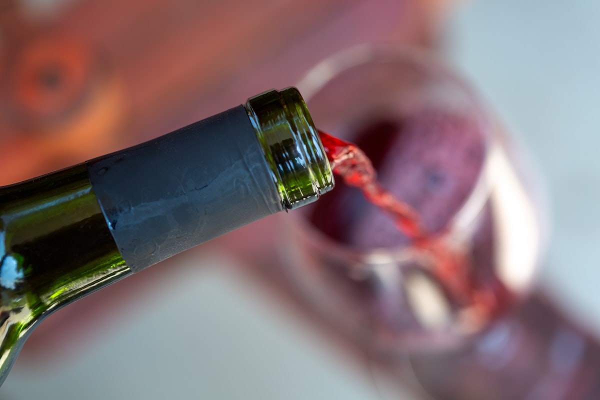 A close-up shot capturing the graceful pour of a deep red wine into a crystal-clear glass, highlighting the rich color and inviting aroma. related to Wine Valance: A Stylish Addition to Your Kitchen
