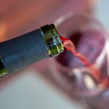 A close-up shot capturing the graceful pour of a deep red wine into a crystal-clear glass, highlighting the rich color and inviting aroma. related to Wine Valance: A Stylish Addition to Your Kitchen