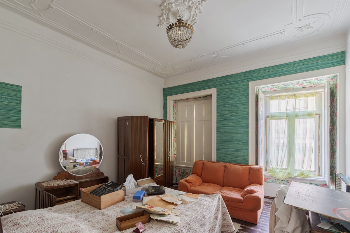 A cluttered bedroom with an orange sofa and vintage furniture. related to The Perfect Blend of Style and Function: Exploring the Purple Sofa Bed