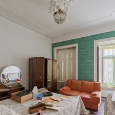A cluttered bedroom with an orange sofa and vintage furniture. related to The Perfect Blend of Style and Function: Exploring the Purple Sofa Bed