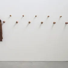 a coat hanging on a wall next to a coat rack related to Elevate Your Entryway with Style: The Ultimate Guide to Entryway Coat Hooks