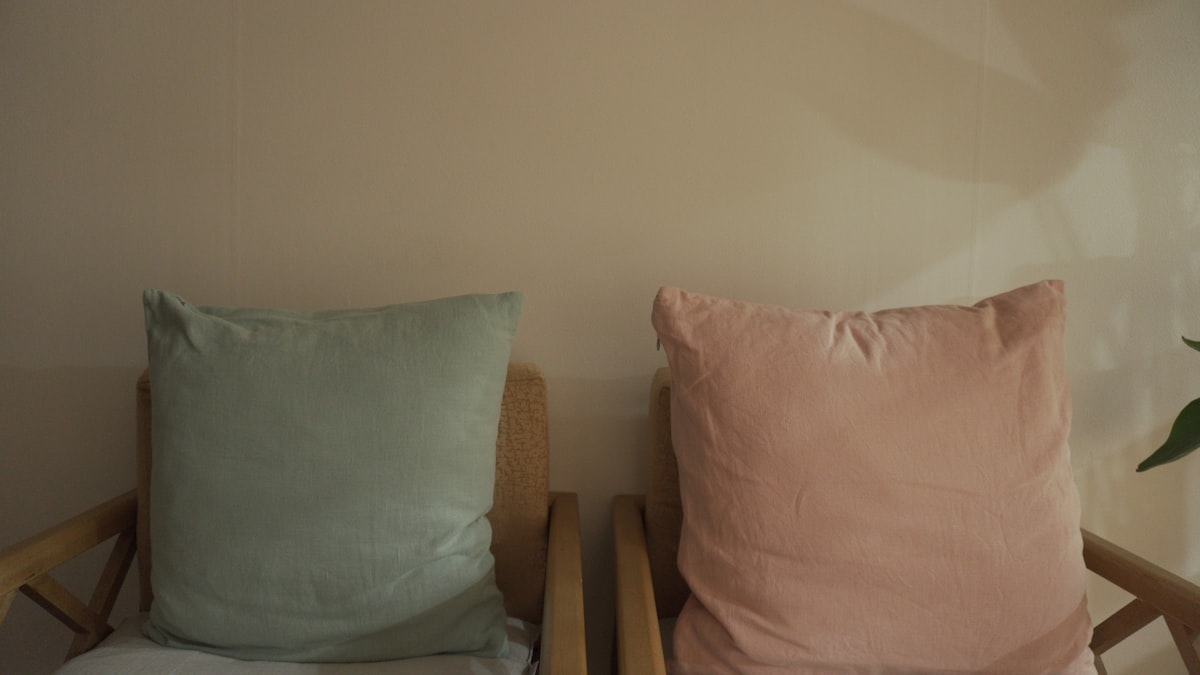 a couple of pillows sitting on top of a wooden chair related to Best Bed Chair Pillows for Comfort and Support