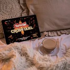 A cozy bed featuring a tablet (iPad) playing "Yu-Gi-Oh! Cross Duel" on display + a cup of cappuccino || I decided to join in Konami's (Yu-Gi-Oh! Card Game 25th Anniversary) fun & create a series of photos featuring the latest Yu-Gi-Oh games/apps || 📸 Photo by: Jovan Vasiljević related to Revolutionizing Your Slumber: The Ultimate Chili Pad for Bed Experience
