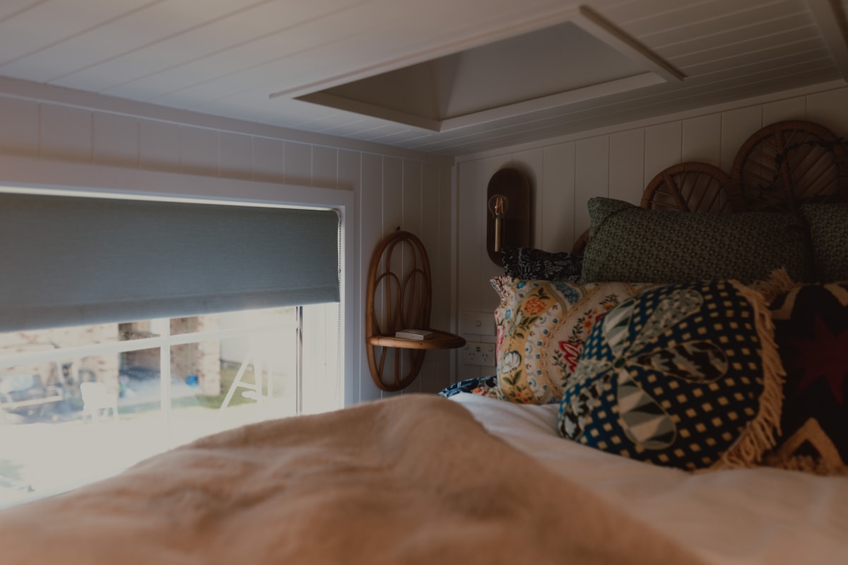 A cozy bedroom with a bed, window, and skylight. related to Elevate Your Bedroom with the Perfect Decorative Bed Pillows