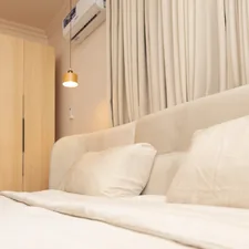A cozy bedroom with a large bed and light-colored decor. related to Ultimate Guide to Air Beds for Comfort