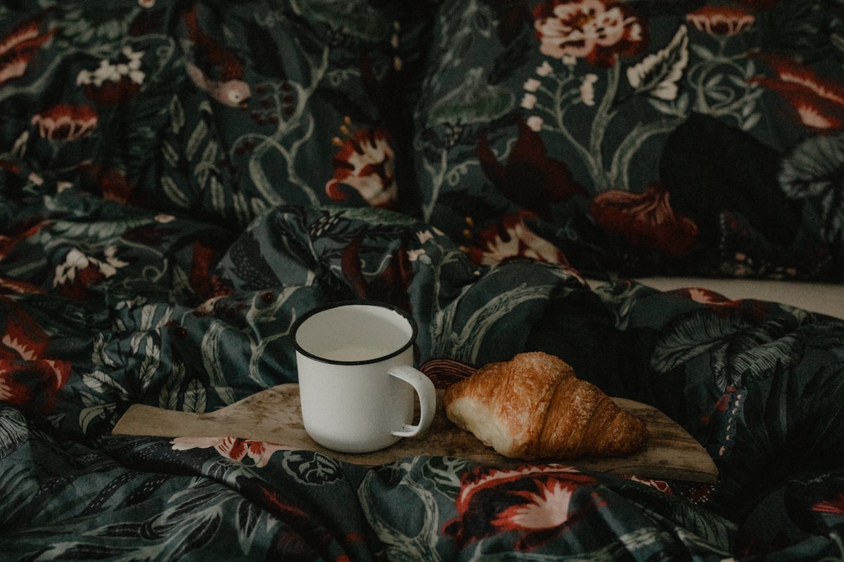 a cup of coffee on a floral blanket related to Beyond Pancakes: Elevating Your Breakfast in Bed Experience