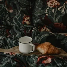 a cup of coffee on a floral blanket related to Beyond Pancakes: Elevating Your Breakfast in Bed Experience