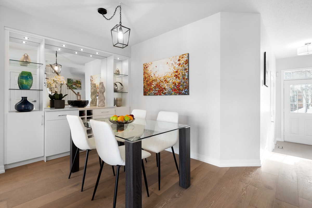 a dining room with a glass table and white chairs related to Elevate Your Dining Experience: Choosing the Perfect Sideboard