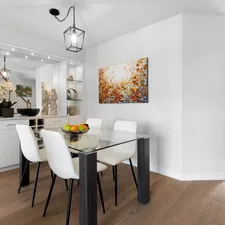 a dining room with a glass table and white chairs related to Elevate Your Dining Experience: Choosing the Perfect Sideboard