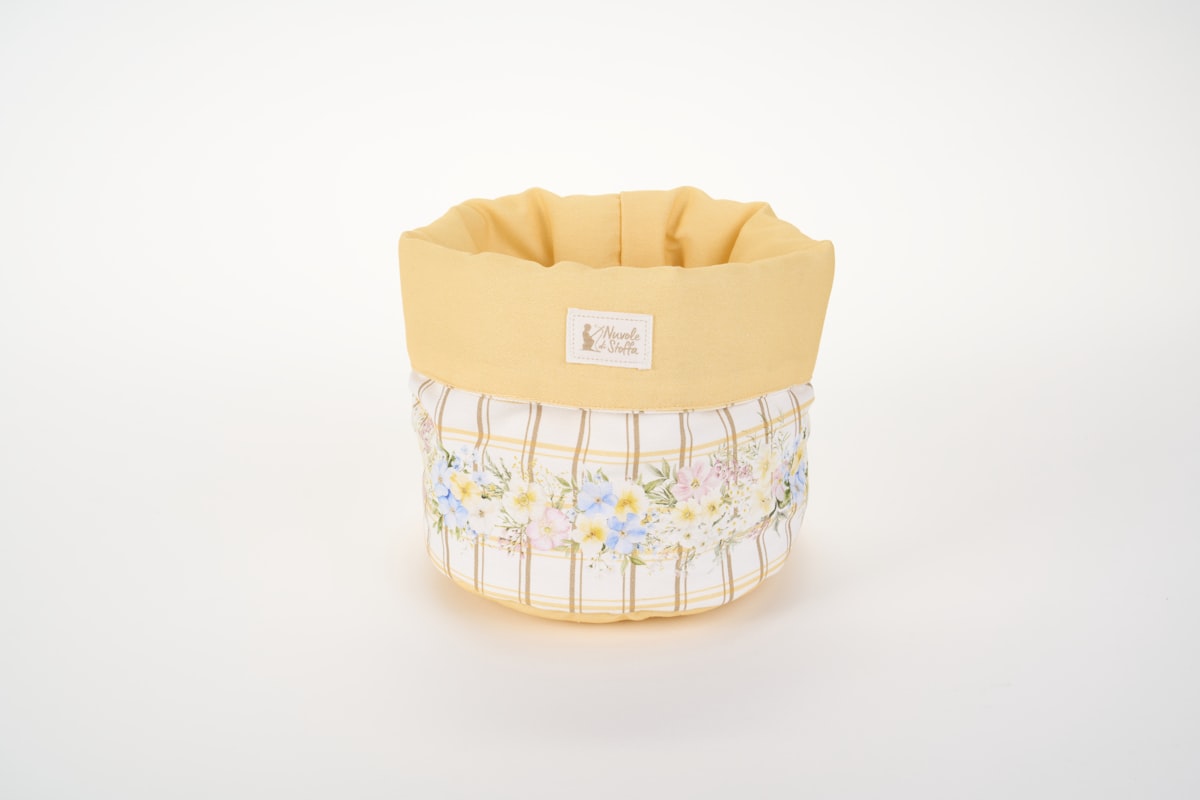 A fabric storage basket with a yellow rim and floral plaid pattern related to Transform Your Bedroom with a Yellow Bed in a Bag