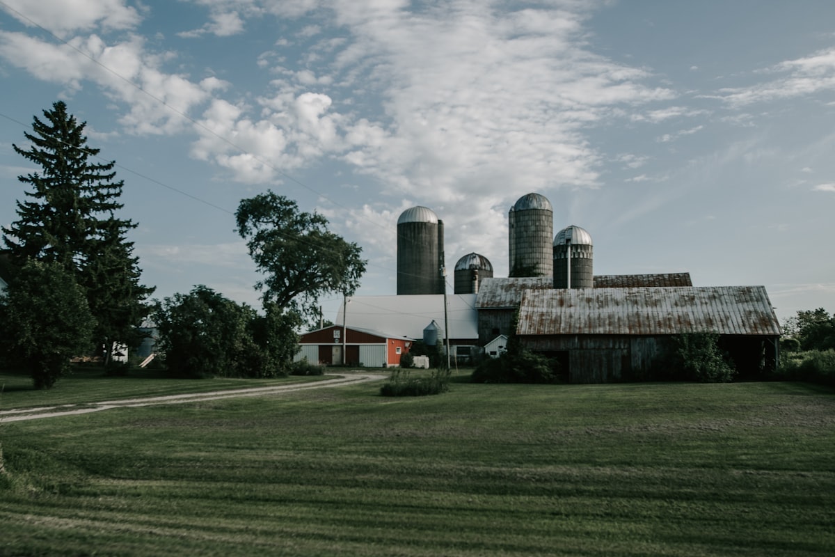 a farm with a barn and silos in the background related to Cozy Getaways: The Best Bed and Breakfast Wisconsin Has to Offer