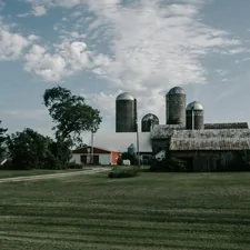a farm with a barn and silos in the background related to Cozy Getaways: The Best Bed and Breakfast Wisconsin Has to Offer