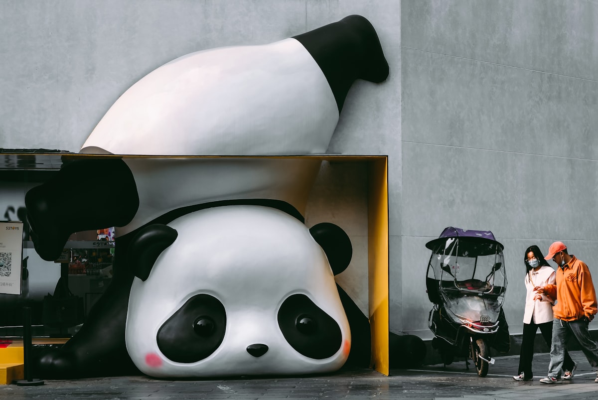 a giant panda bear statue sitting next to a building related to Panda Crib Bedding: The Perfect Blend of Cuteness and Comfort